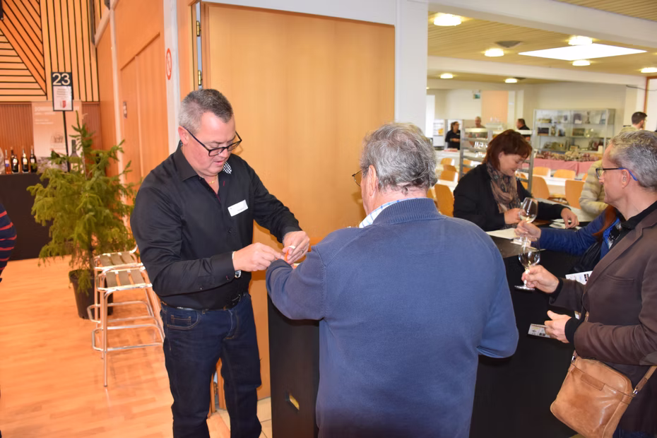 Un visiteur échange avec un exposant à un stand de dégustation.