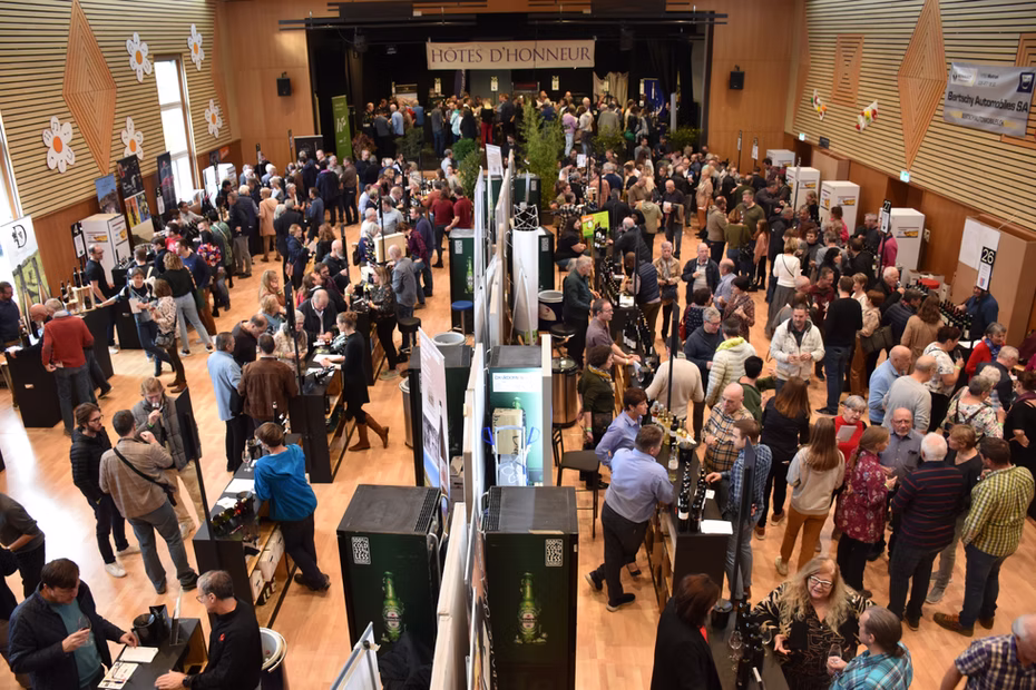 Vue d'ensemble des visiteurs et des stands dans la salle de Festivins.