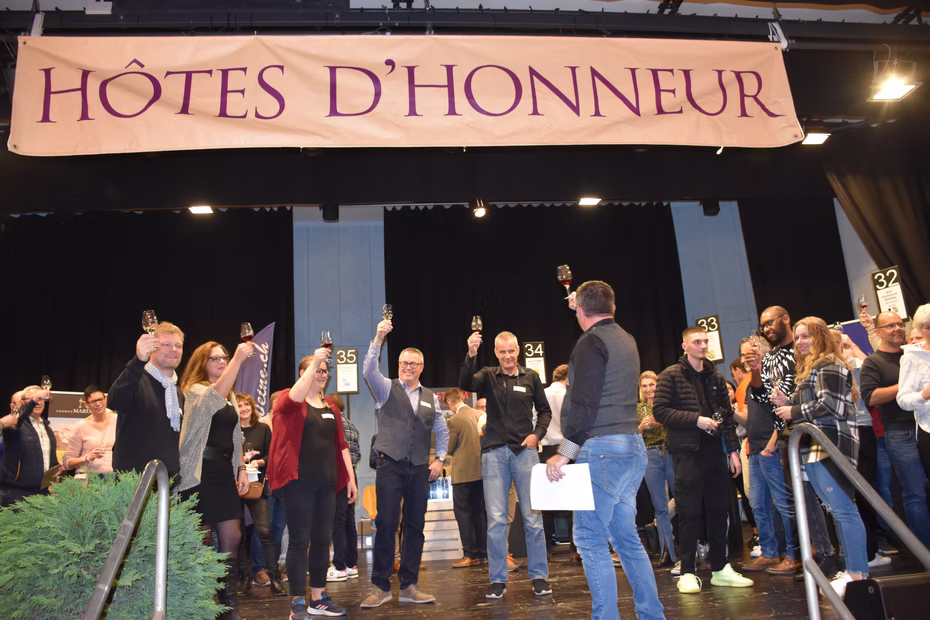 Un groupe réuni sur la scène sous la bannière des hôtes d'honneur.