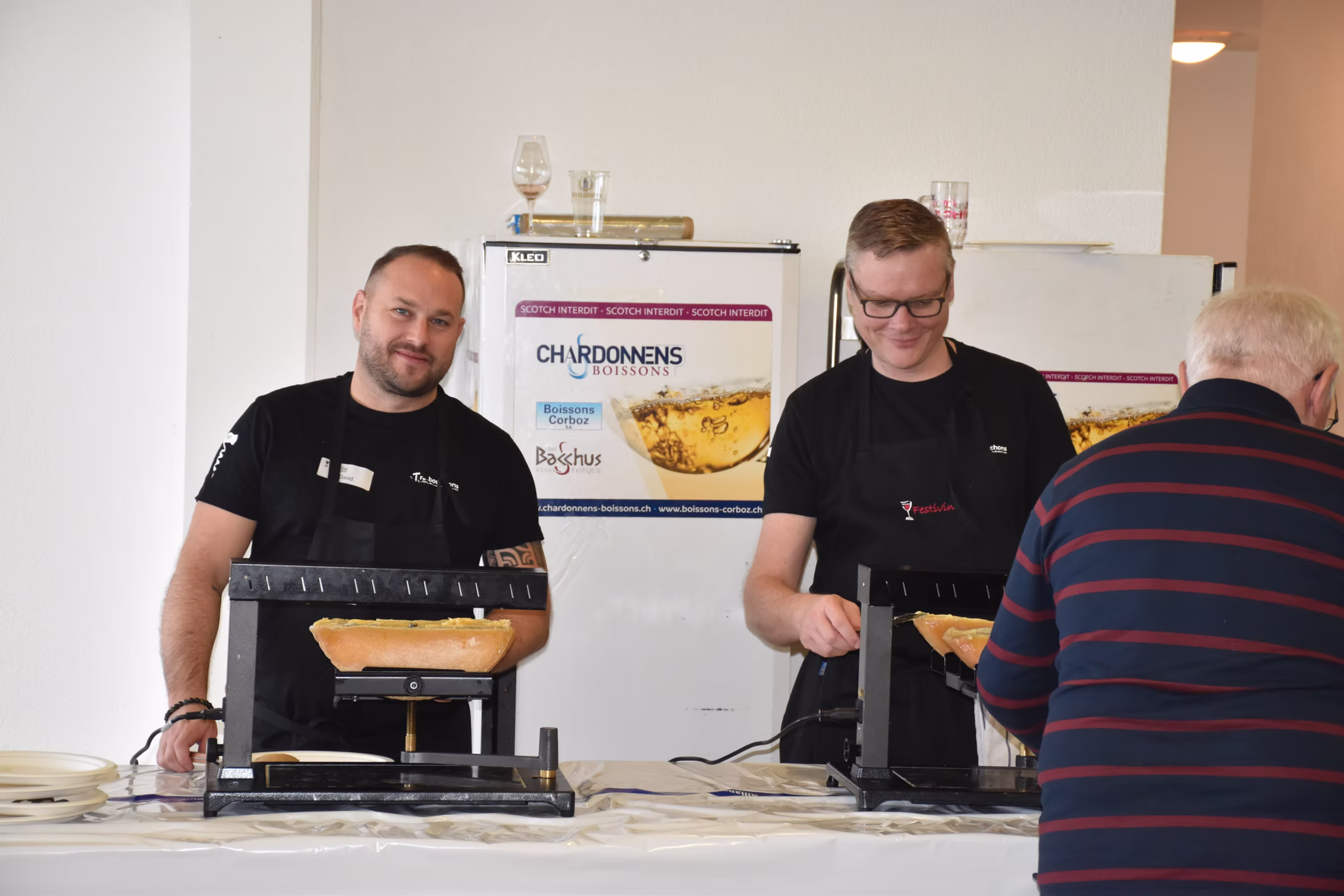 Deux bénévoles servent les visiteurs au comptoir de restauration.