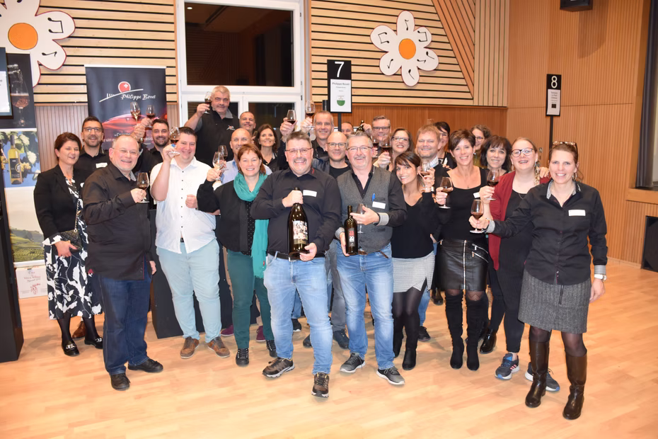 Un groupe de participants pose ensemble dans la salle du salon.